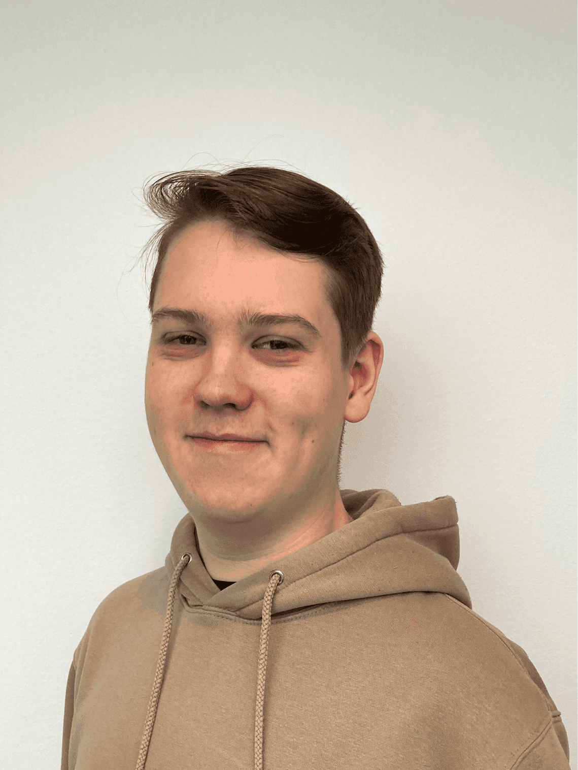 Portrait of a young man wearing a student cap and a black suit with a red tie.